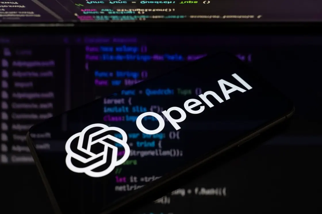 スマートフォンに表示されたOpenAIのロゴとコード画面