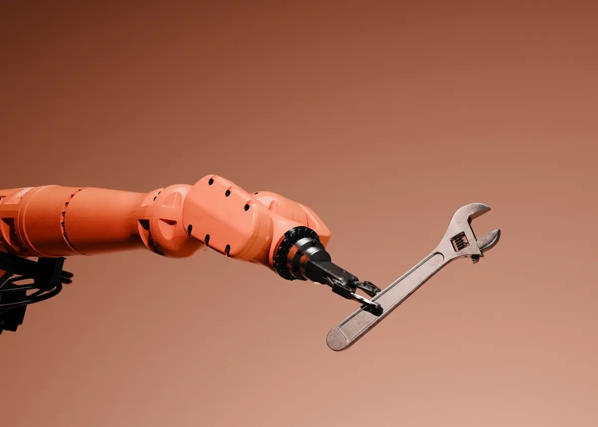 オレンジ色のロボットアームがレンチをつかんでいる写真