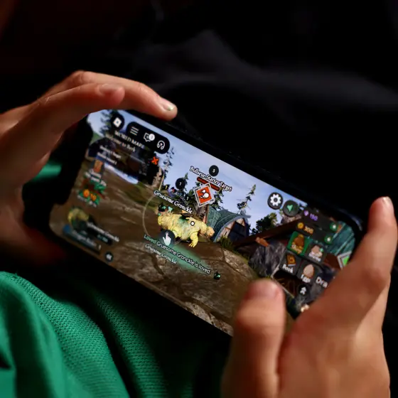 スマートフォンでゲームアプリを操作する手元のクローズアップ