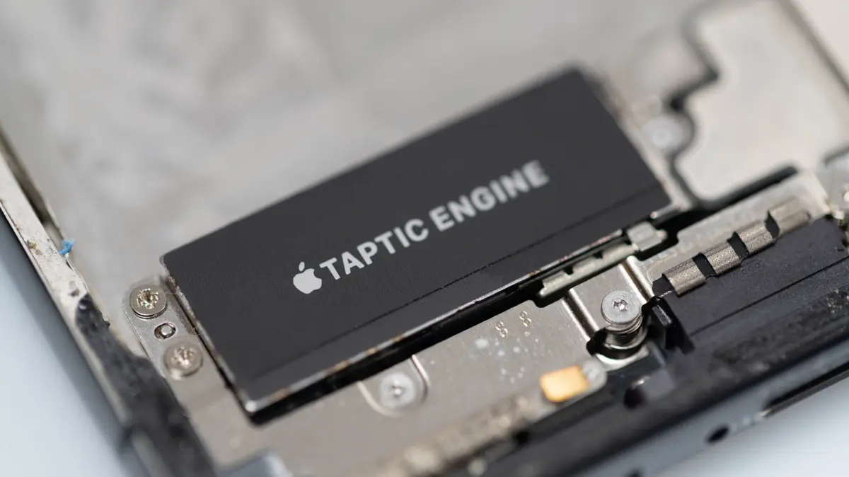 分解されたiPhoneの内部に取り付けられた、Appleのロゴと「TAPTIC ENGINE」の刻印が入った黒い部品