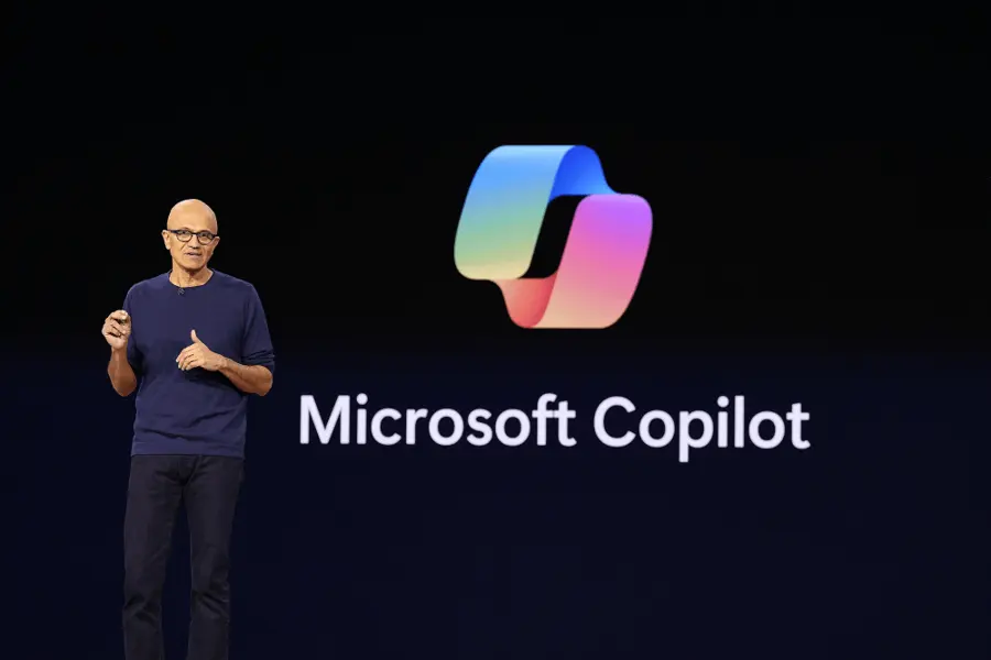 濃紺の背景でMicrosoft CopilotのロゴとともにSatya Nadella氏が登壇して話している写真